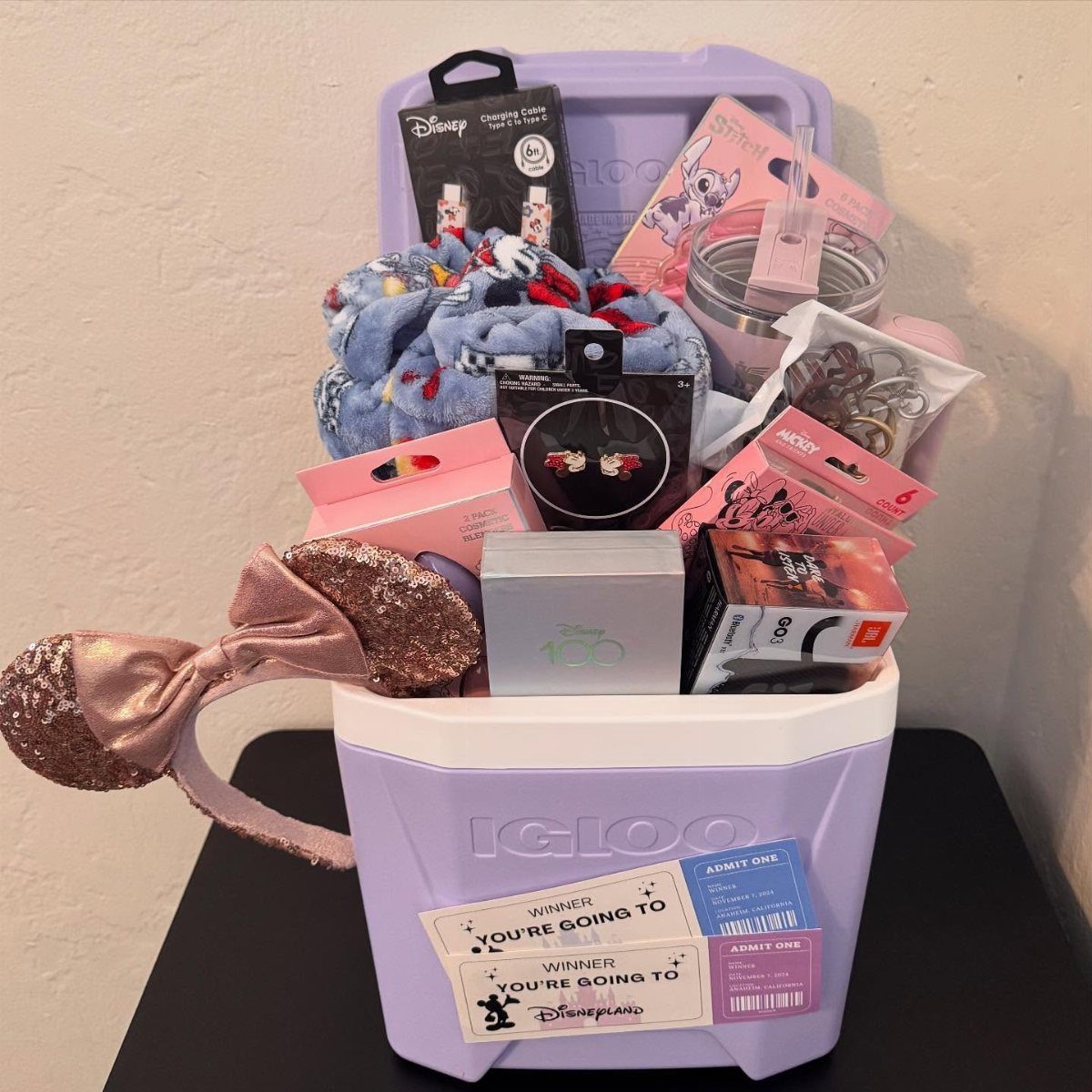 Disney-themed raffle basket in a purple cooler with Minnie Mouse ears and tickets.