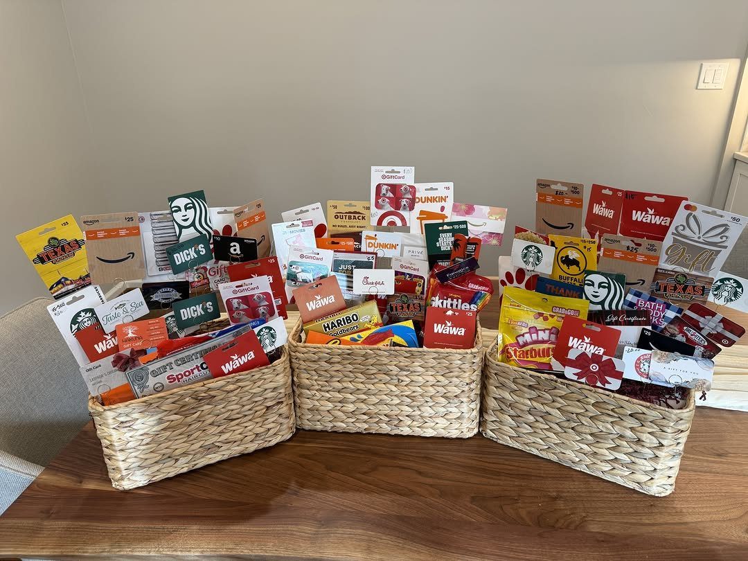 Three wicker baskets filled with various colorful gift cards and small candies.