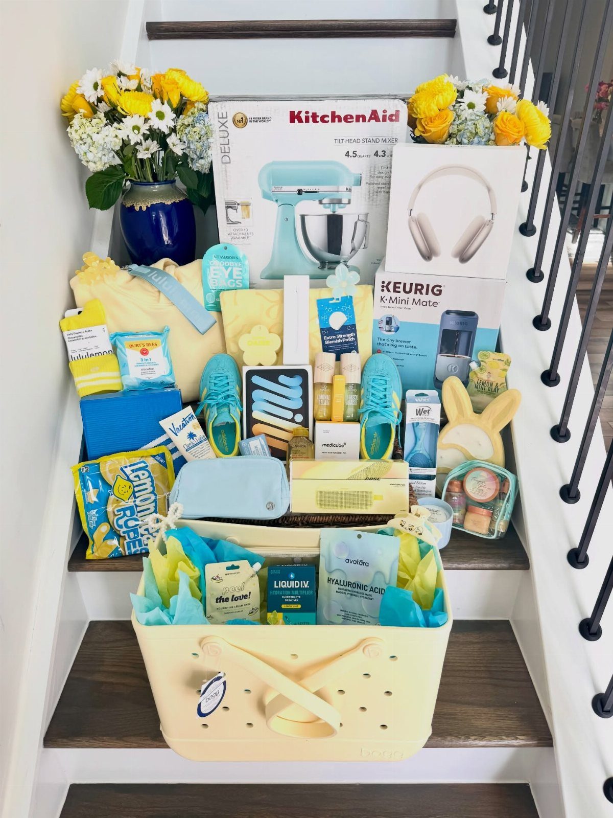 Assorted blue and yellow gift items and appliances arranged on wooden stairs.