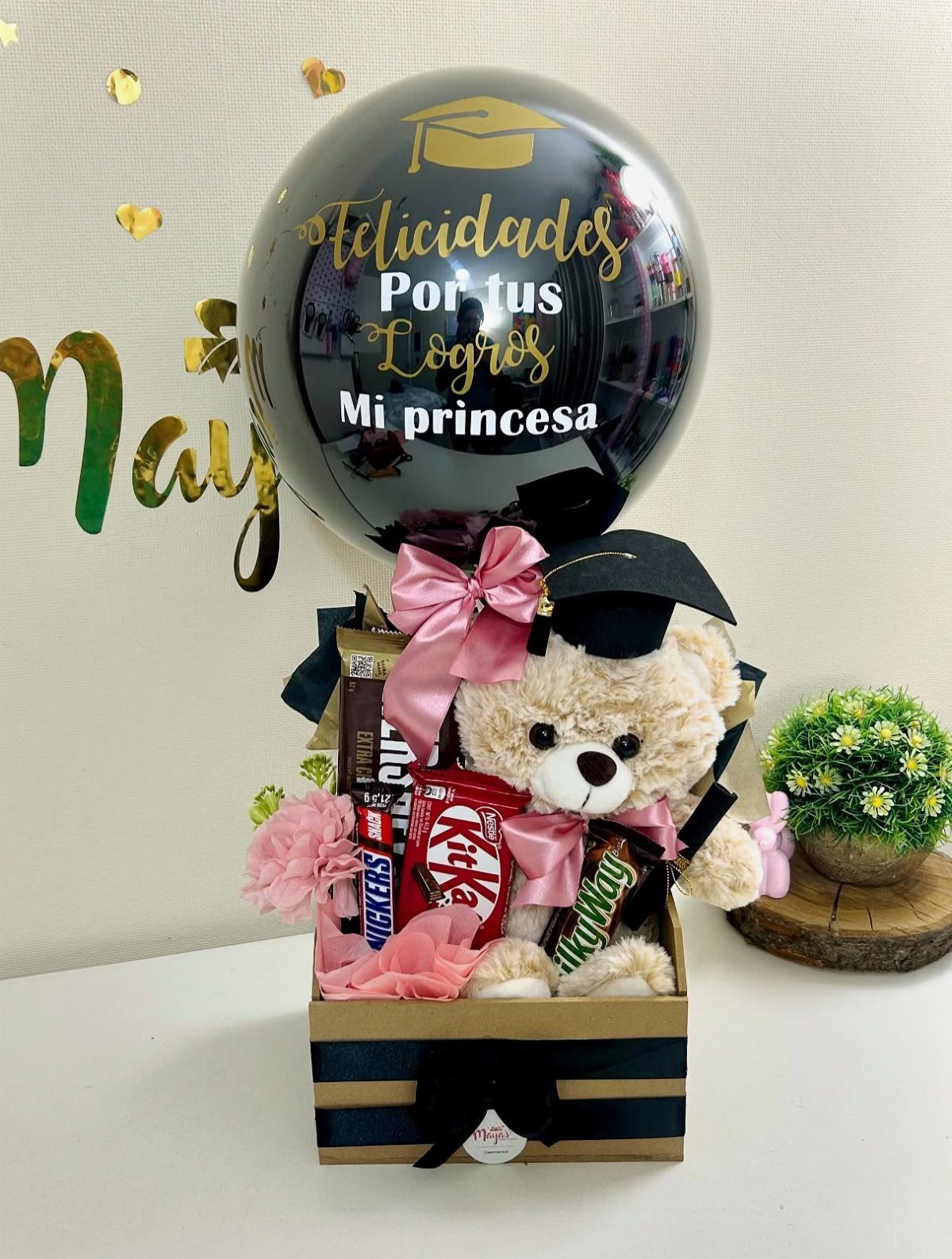 Graduation gift basket with a teddy bear, chocolates, and a personalized black balloon.