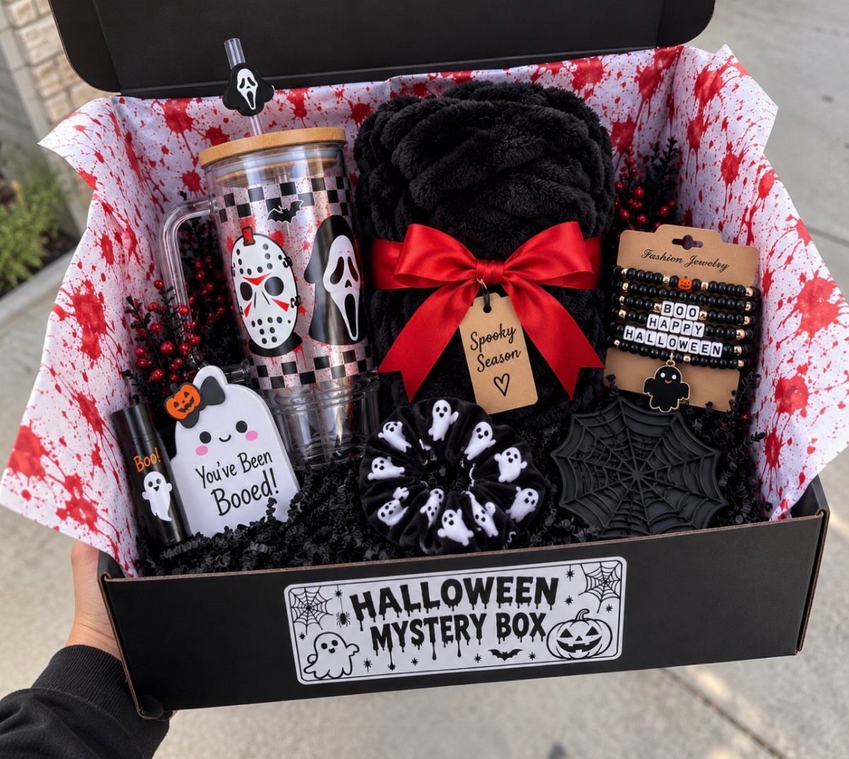 Halloween mystery box containing a Ghostface tumbler, black blanket, and spooky accessories.