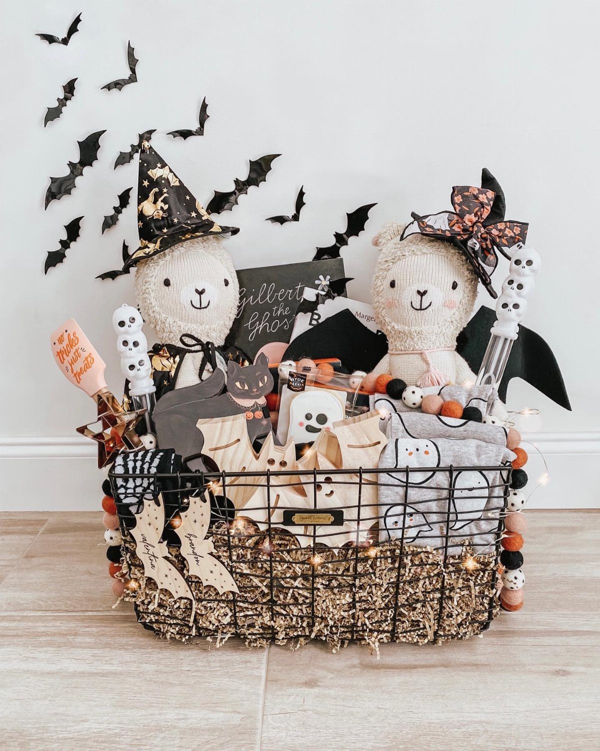 Black wire basket filled with Halloween plushies, ghosts, and spooky themed decorations.