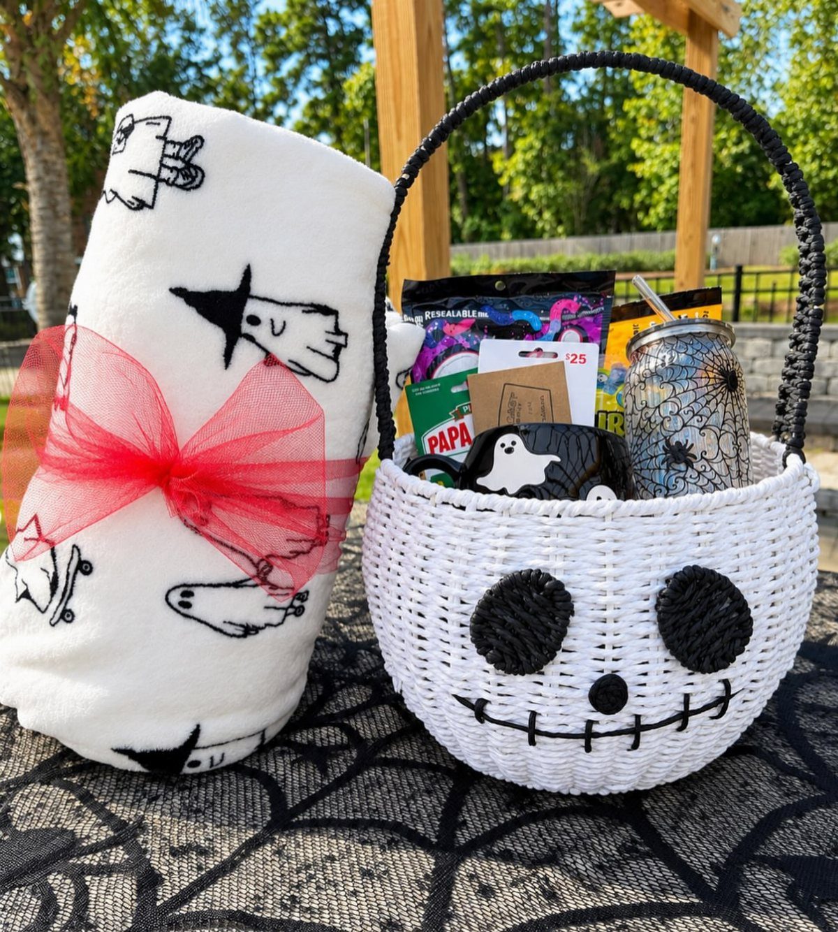 Jack Skellington themed gift basket with ghost patterned blanket and spooky treats