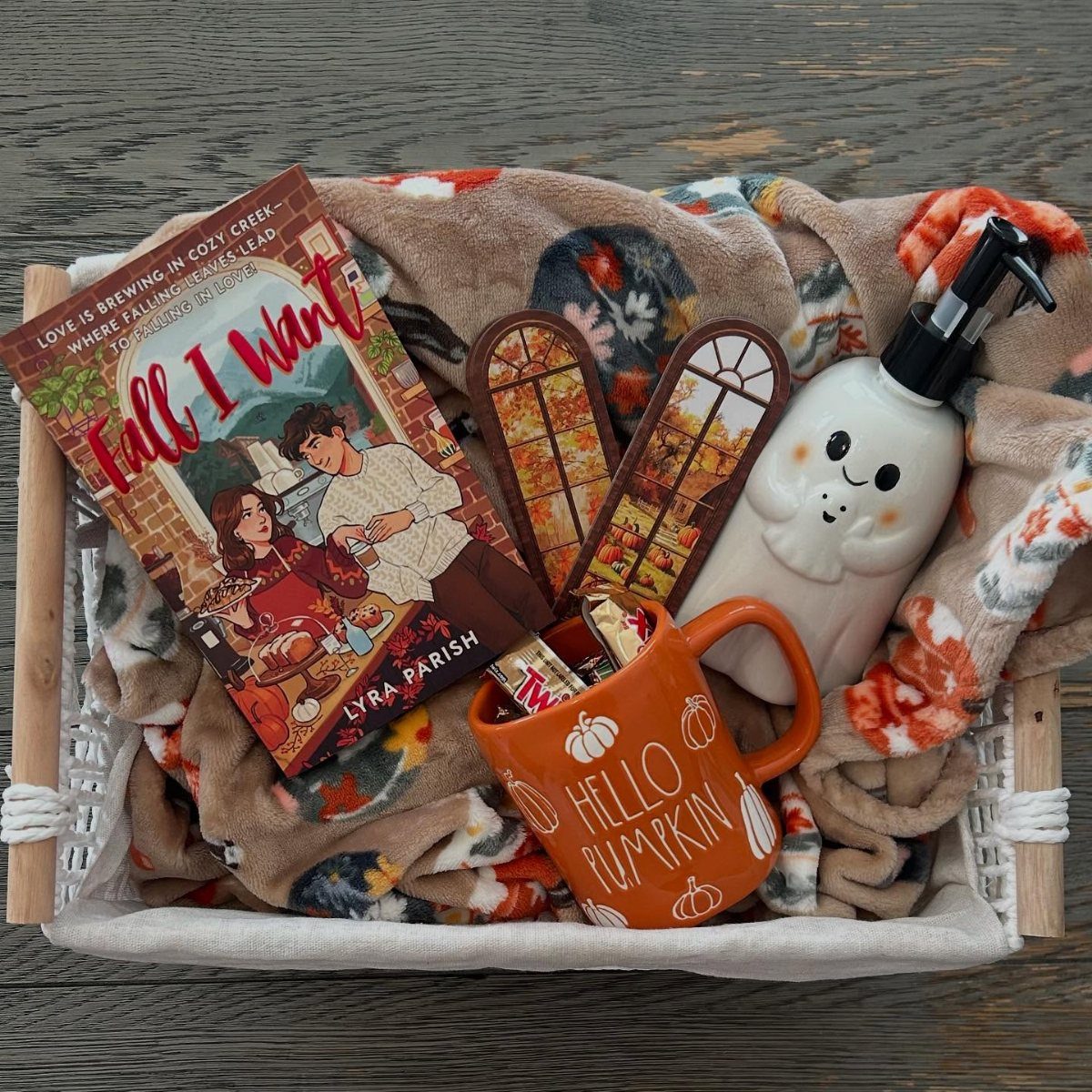 Autumn themed gift basket with a pumpkin mug, ghost dispenser, and fall book.