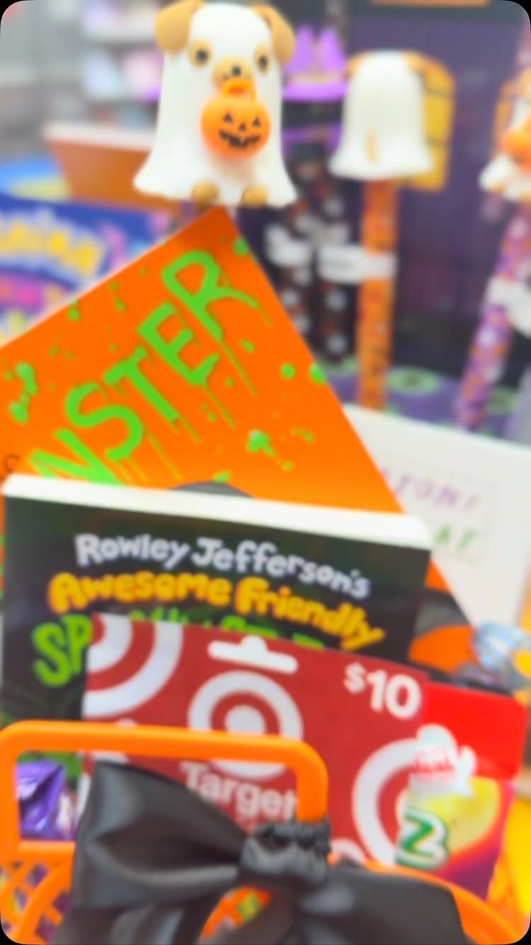 Halloween gift basket with spooky children's books, a gift card, and ghost dog figurine.