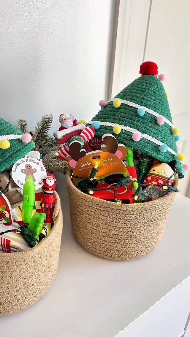 Woven gift baskets filled with Christmas ornaments and topped with green knitted tree hats.
