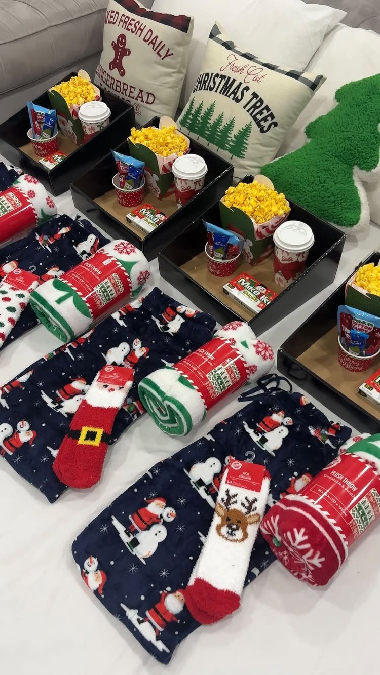 Movie night gift baskets with popcorn and candy next to festive holiday blankets.