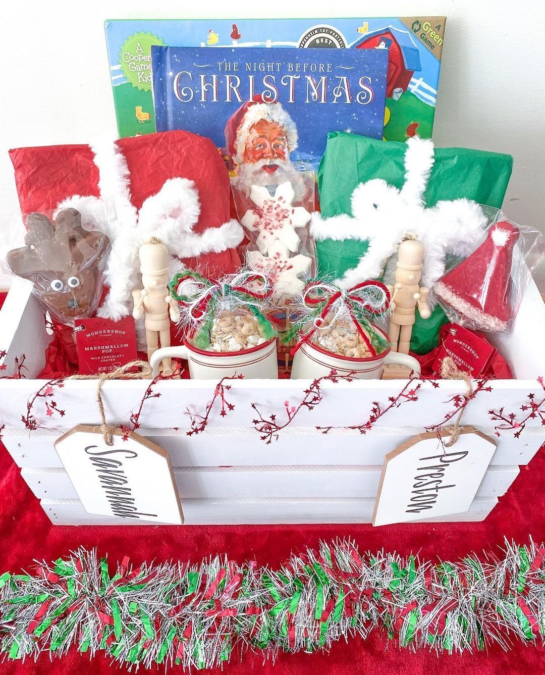 White wooden gift crate filled with Christmas Eve treats, books, and wrapped presents.