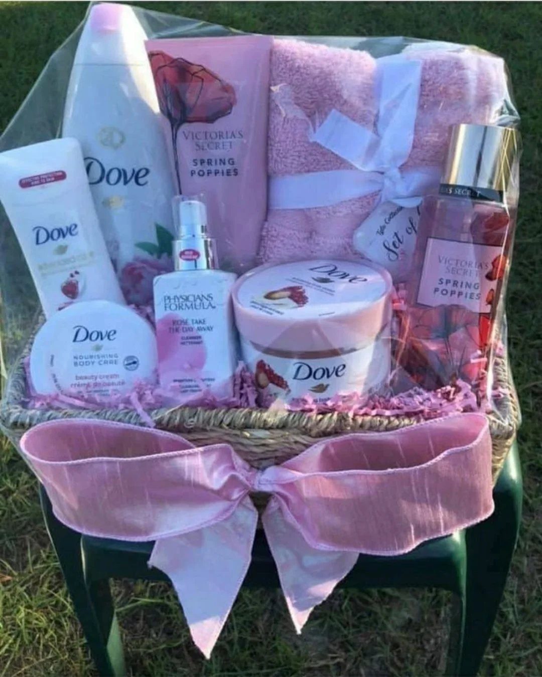 Wicker gift basket filled with pink spa toiletries and a pink towel.