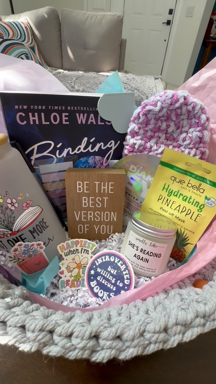 Bookworm gift basket with a novel, pink beanie, candle, and reading-themed stickers.