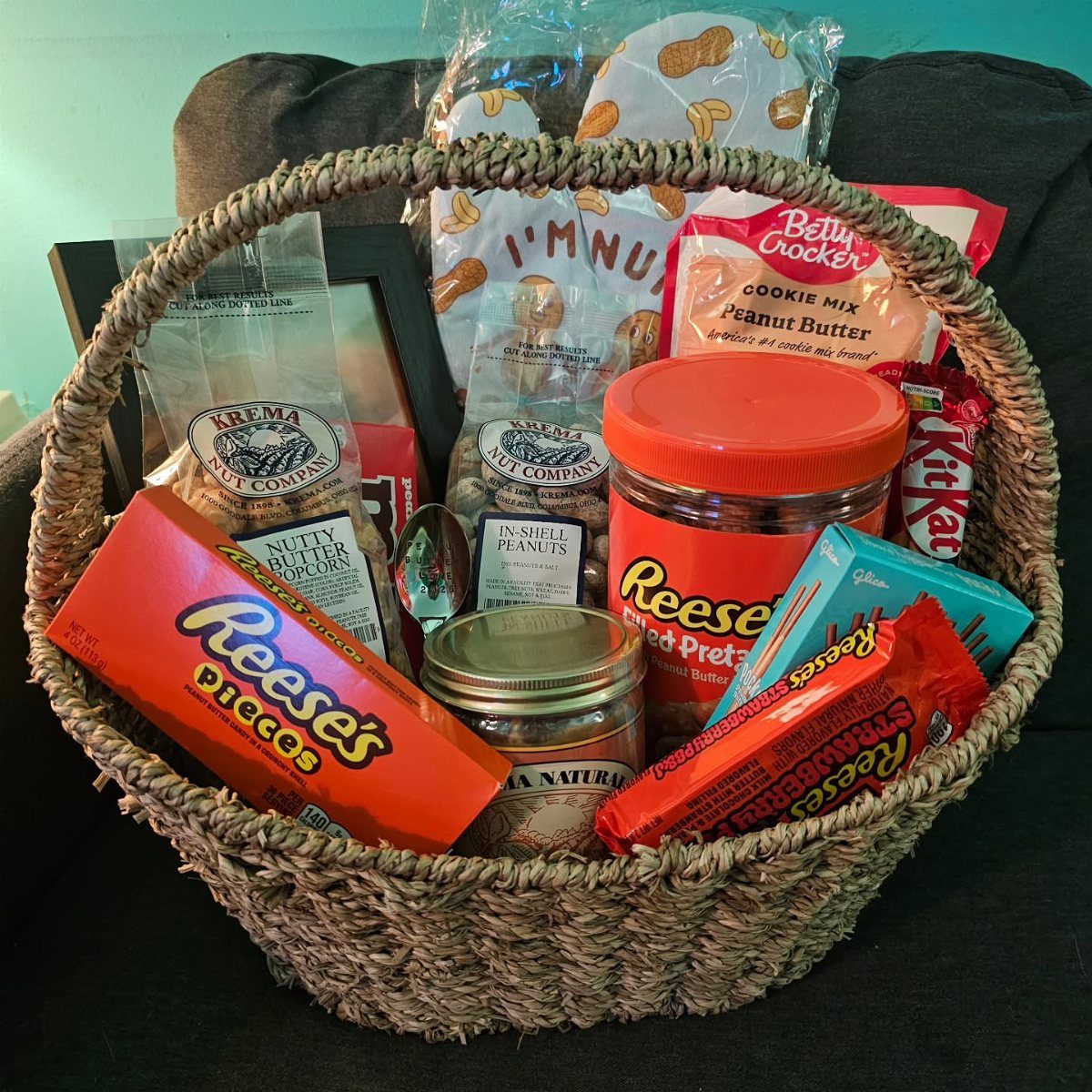 Woven basket filled with peanut butter snacks, candies, and cookie mix.