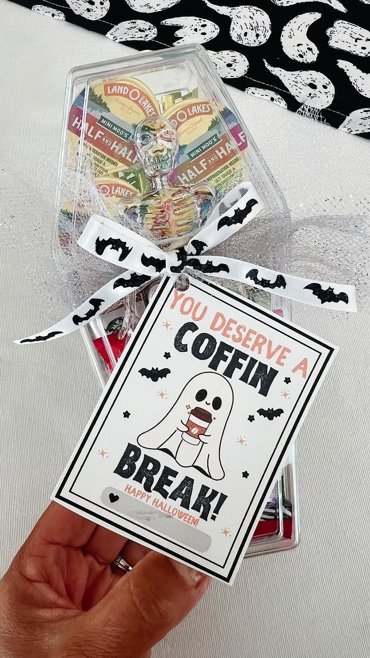 Coffin-shaped clear gift box filled with Halloween treats and a spooky tag.