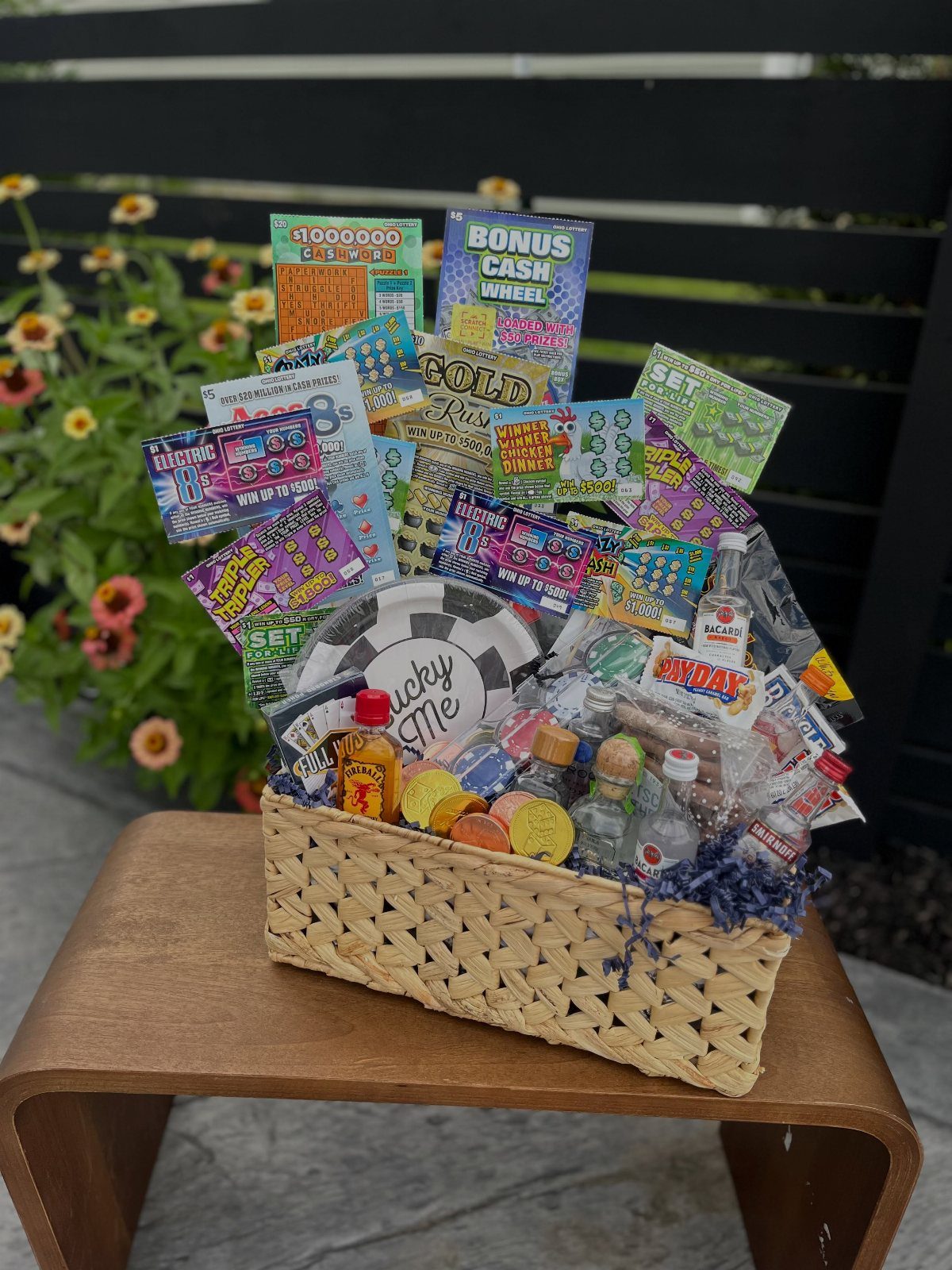 Woven basket filled with lottery tickets, mini liquor bottles, and a poker chip.