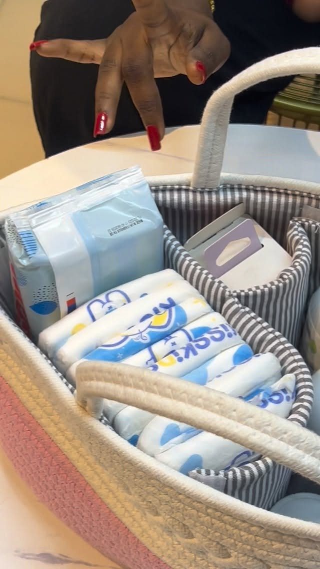 Woven diaper caddy filled with baby wipes and diapers on a white table