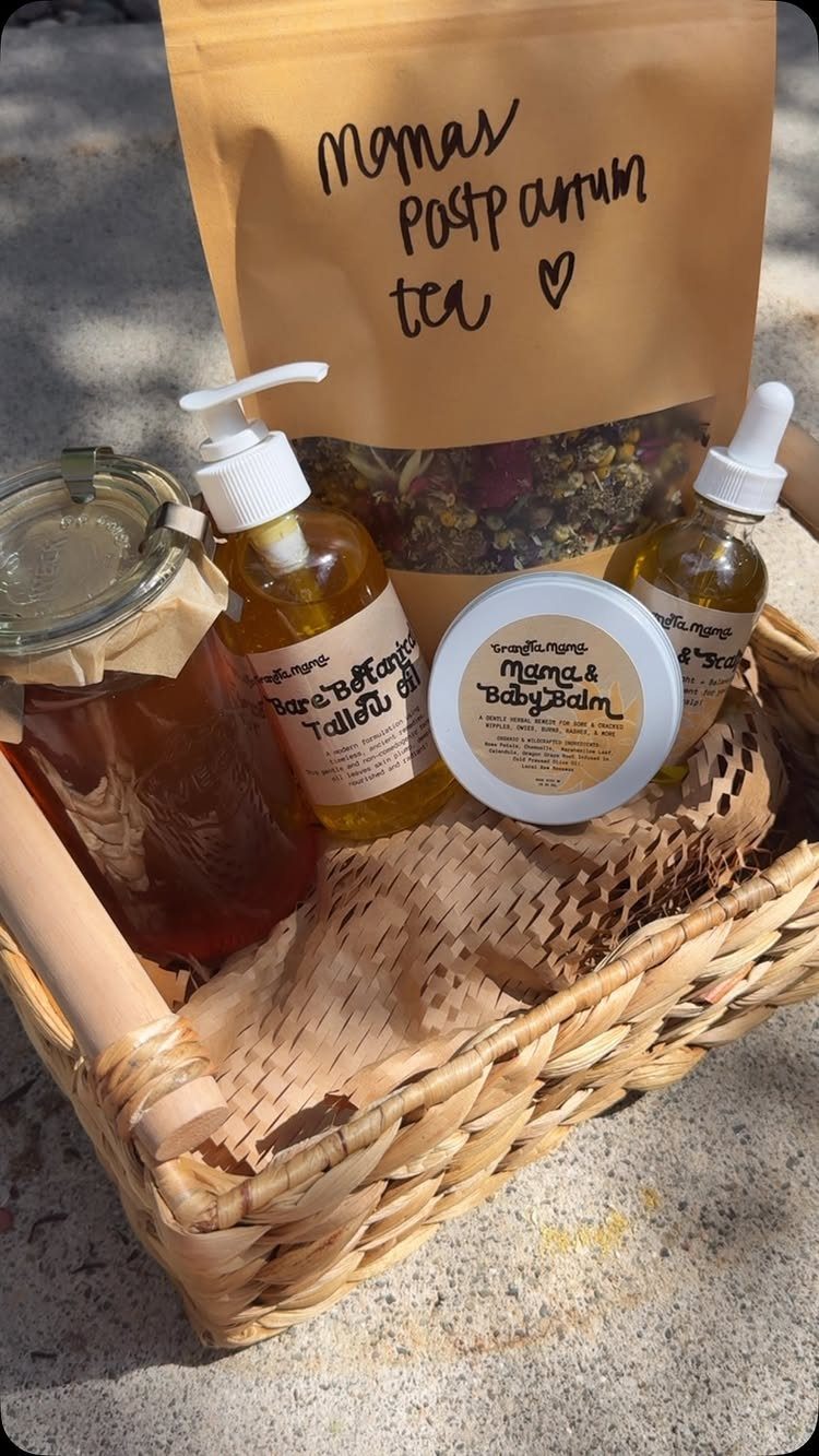 Woven gift basket with postpartum tea, skincare oils, and balm for new mothers.