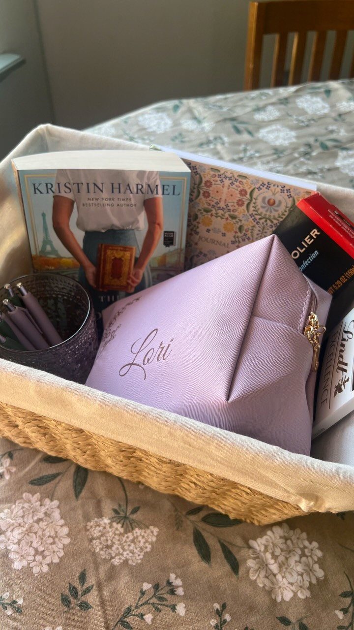 Gift basket with a purple personalized bag, a book, and a notebook.