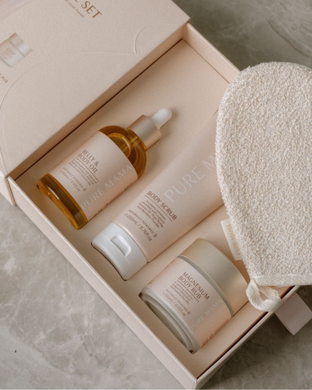 Belly and body oil with scrub and rub in a pink gift box.
