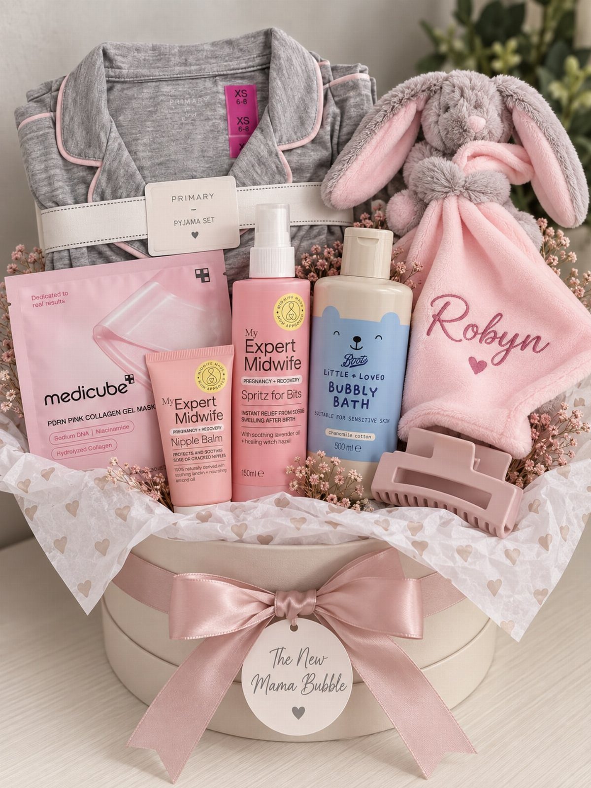 Gift basket for new mother with pajamas, baby blanket, plush bunny, and skincare products.