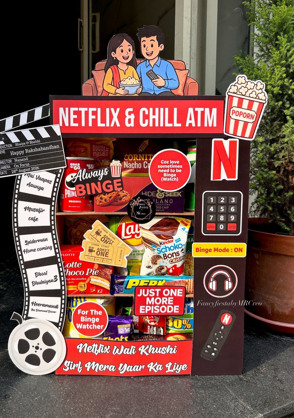 Movie-themed gift box shaped like an ATM filled with assorted snacks and candies.