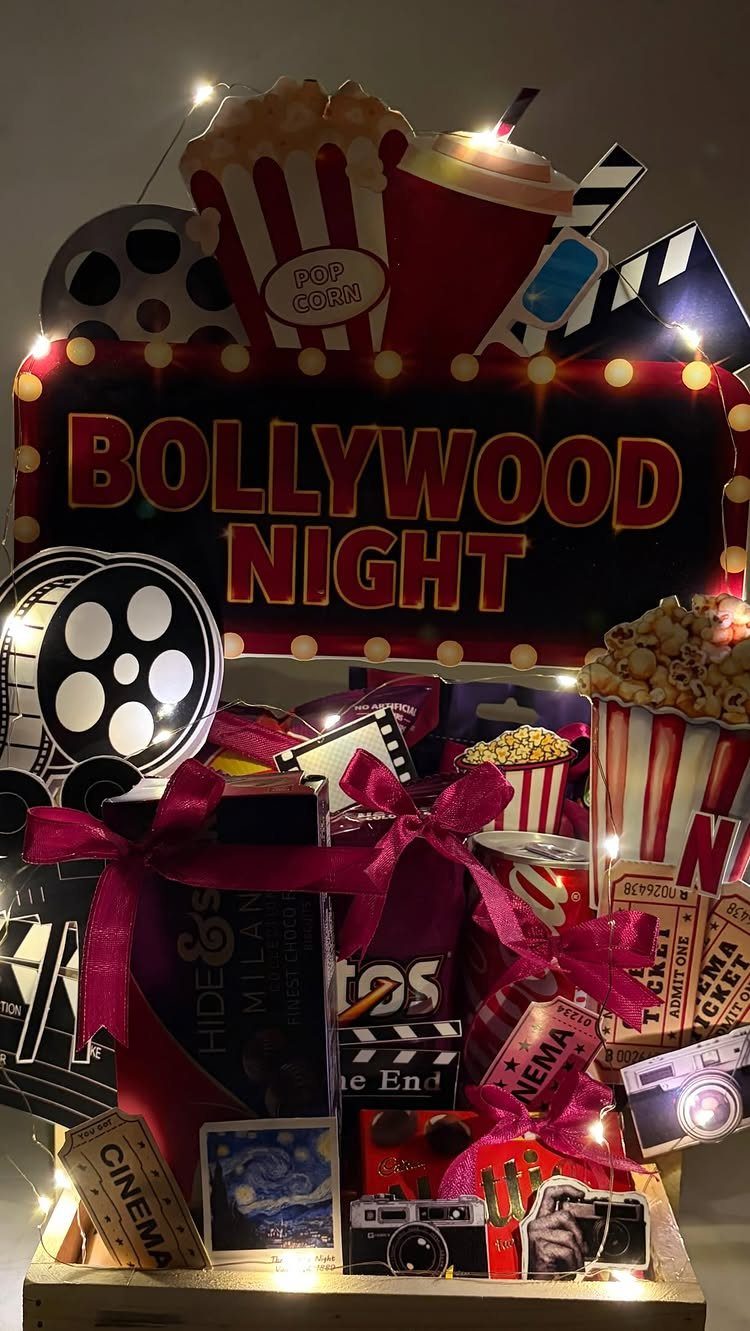 Movie night gift basket with Bollywood sign, popcorn, film reels, and pink ribbons.