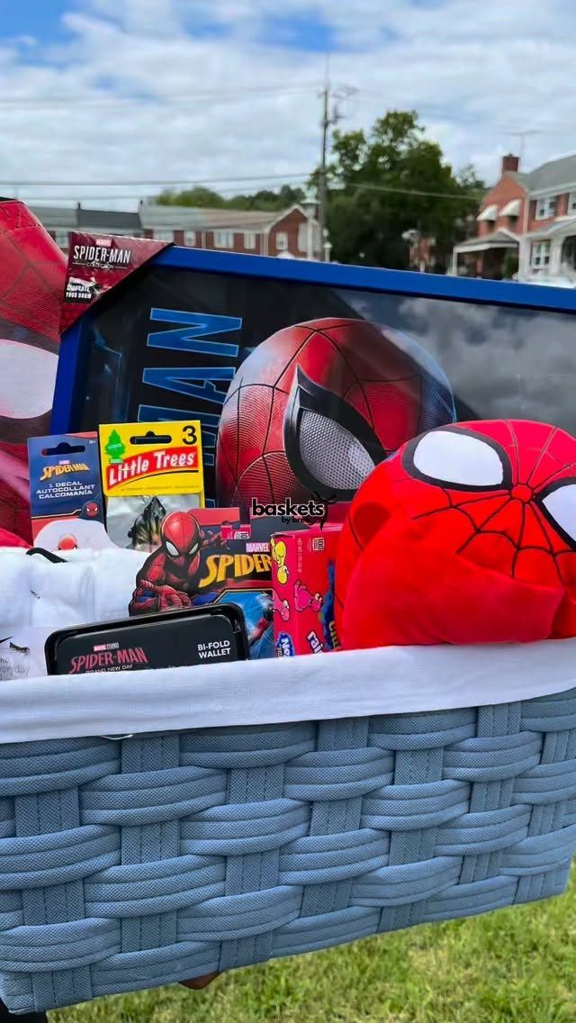 Spider-Man themed gift basket filled with red masks and toys outdoors.