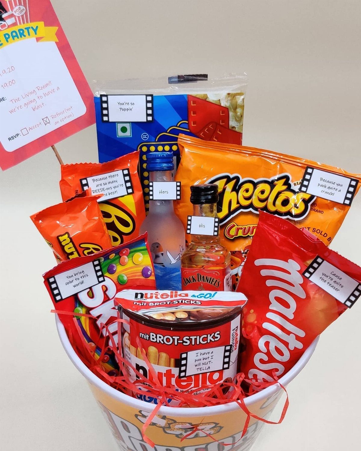 Gift basket filled with assorted snacks and treats in a white bucket.