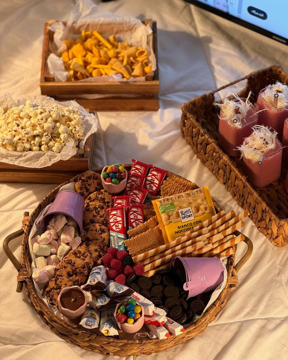 Wicker basket filled with assorted sweets and snacks for a movie night.