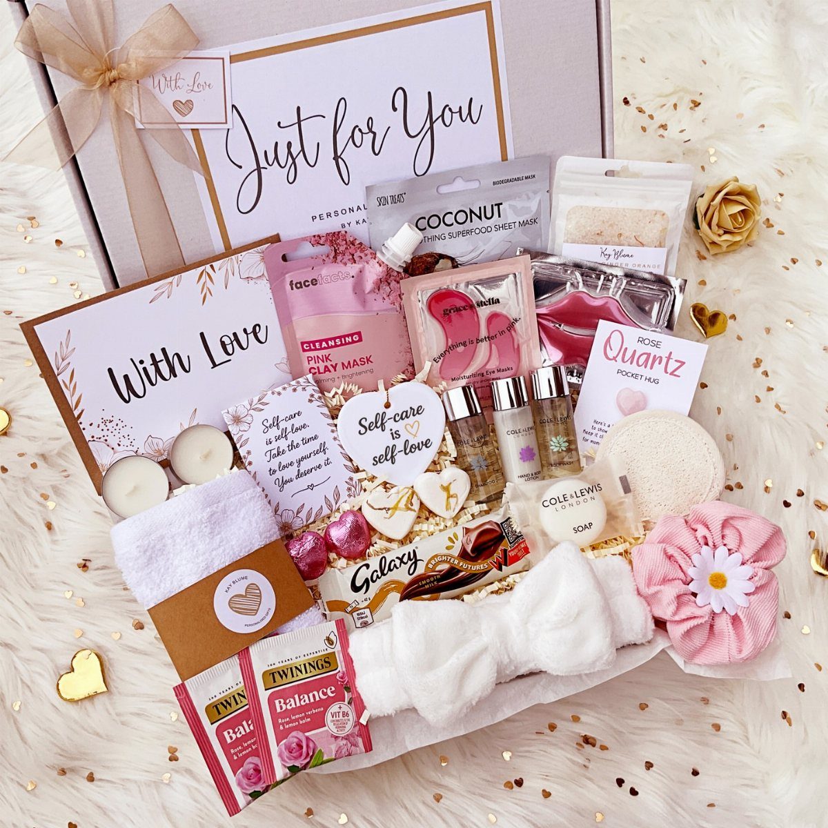 Spa gift box with face masks, candles, and skincare on white faux fur.