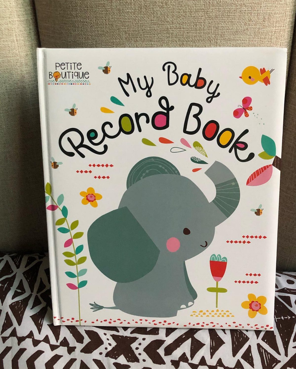 My Baby Record Book with a grey elephant illustration on a patterned surface