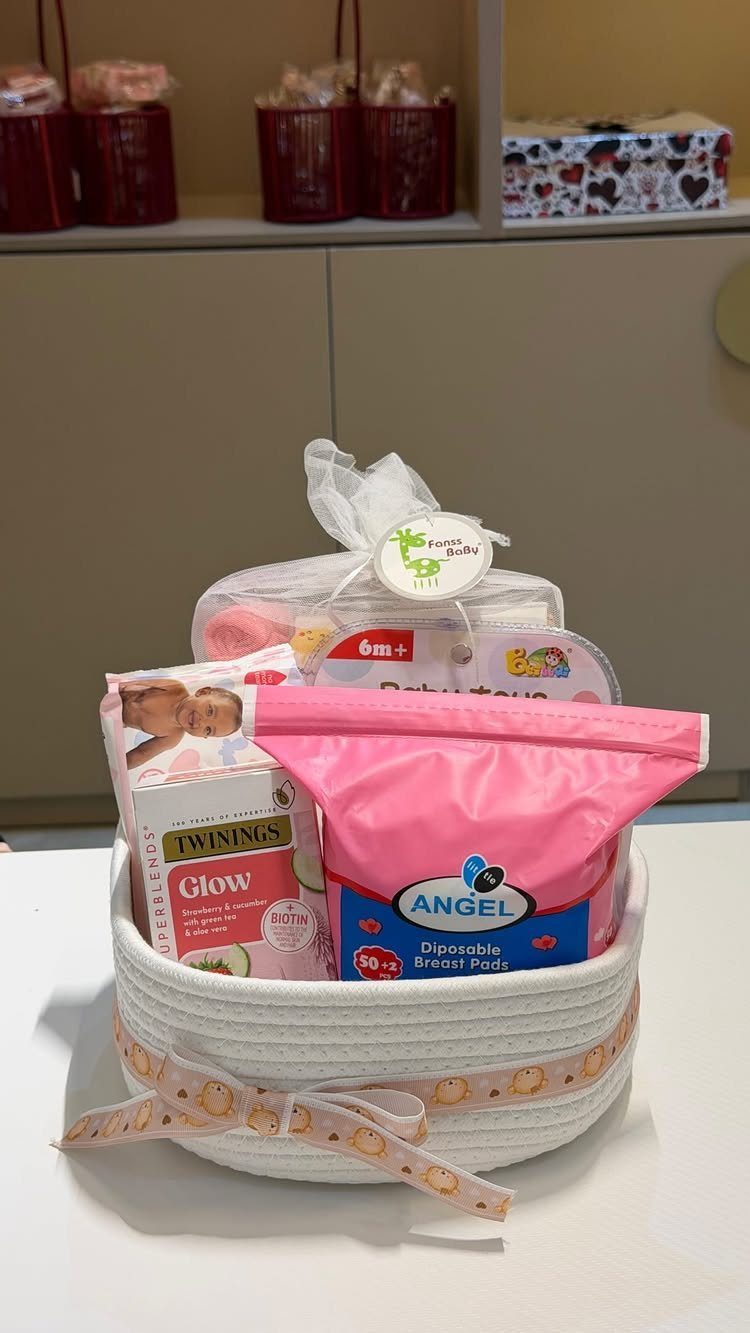 White woven basket filled with breast pads, tea, and maternity care products.