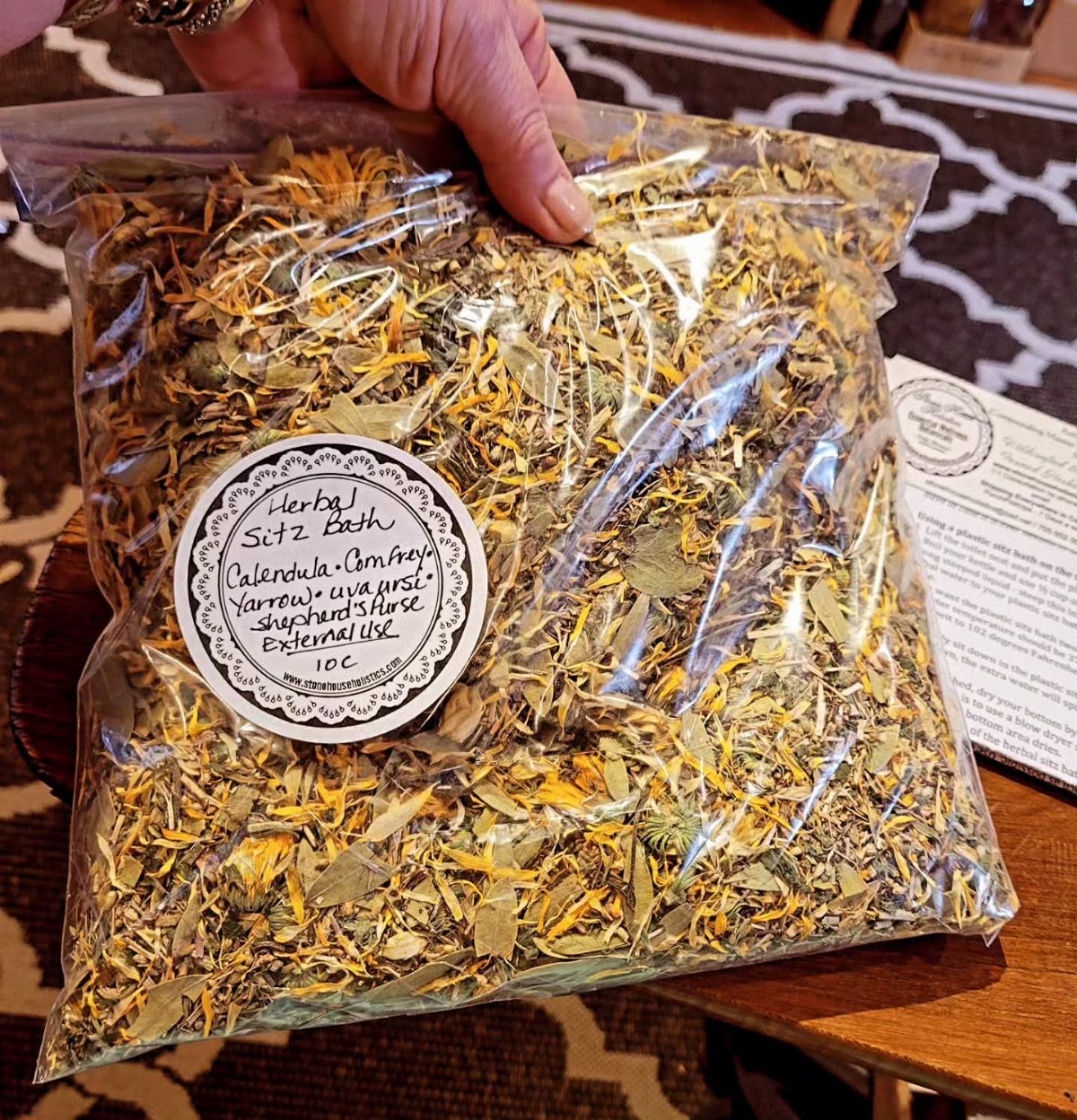 Dried herbal sitz bath mix in a clear plastic bag with a label.