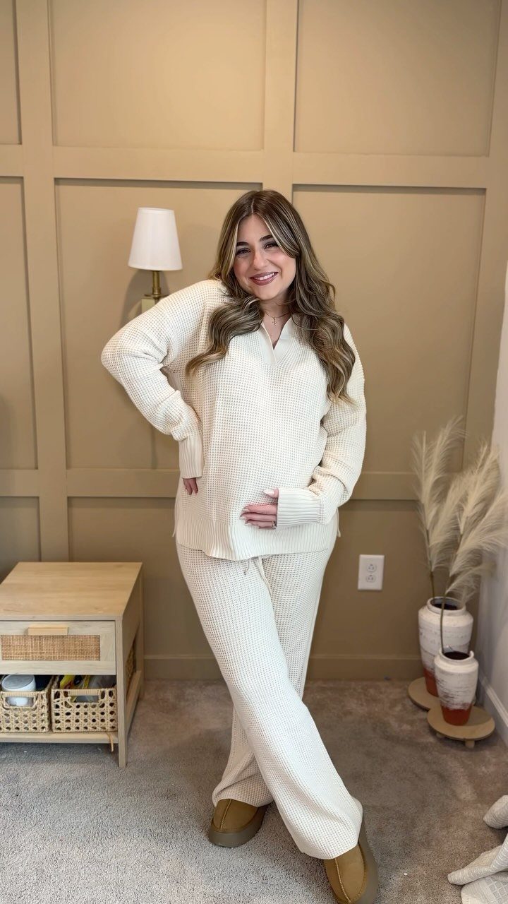 Woman wearing a cream textured knit loungewear set standing in a beige room.