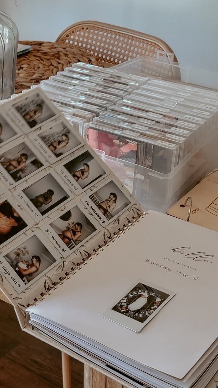 Open scrapbook with baby growth photos next to a bin of photo slides.