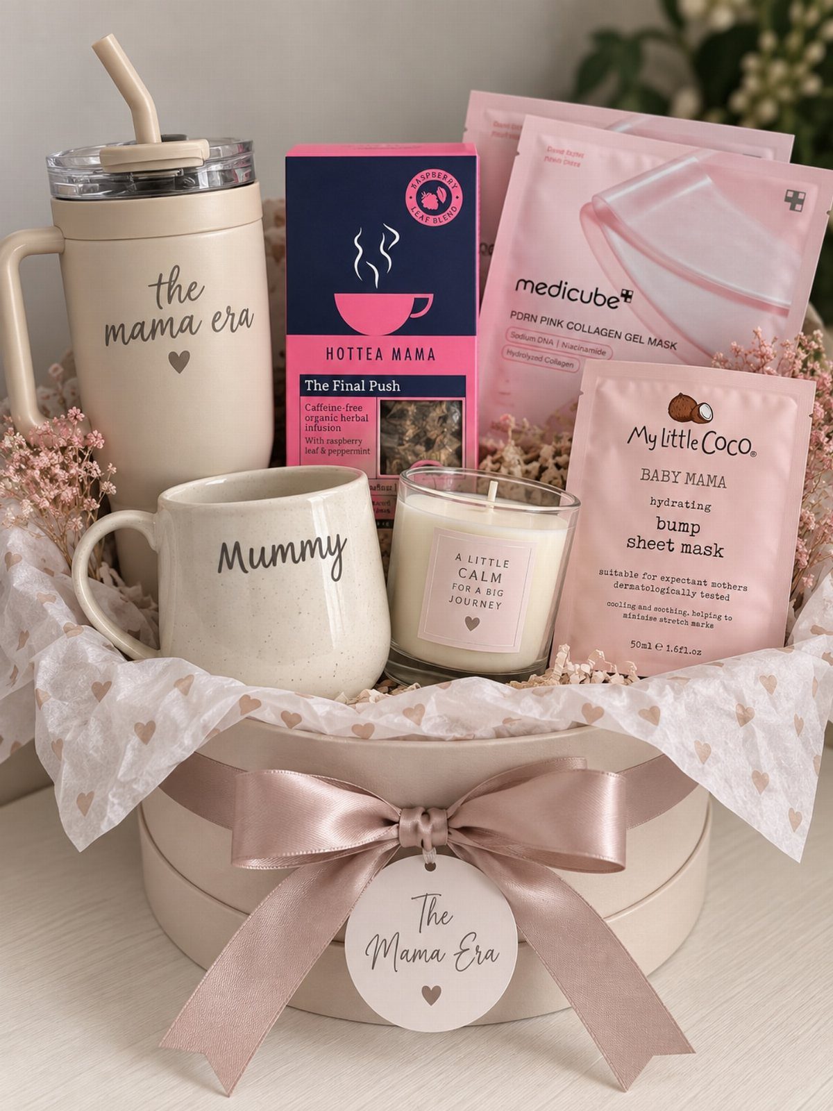 Gift basket for new mothers containing a tumbler, mug, candle, tea, and face masks.