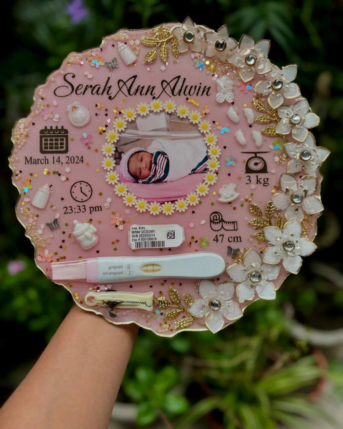Pink resin baby keepsake plaque with photo, pregnancy test, and birth details.