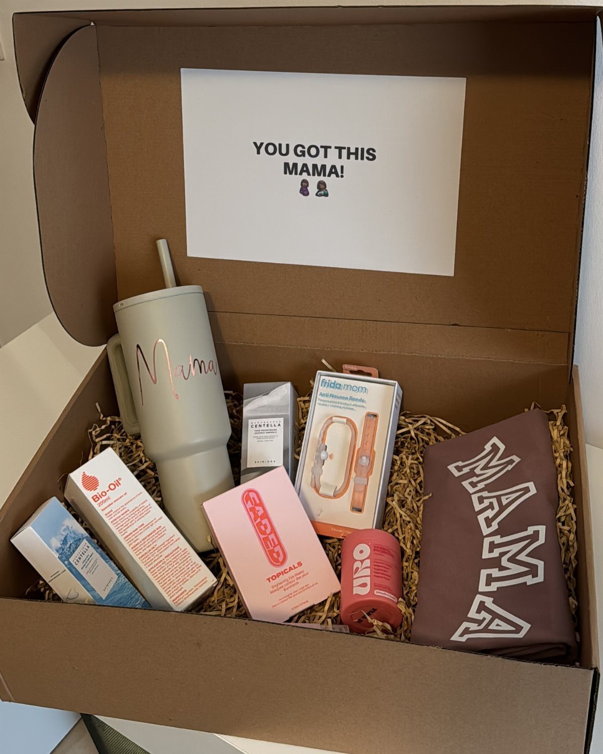 Pregnancy care package in a cardboard box with Mama tumbler and skincare products