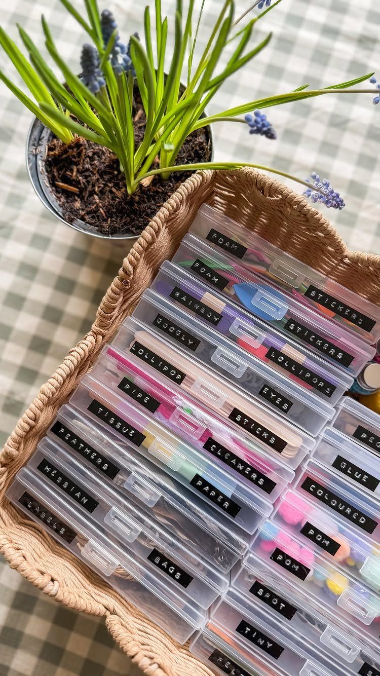Woven basket filled with labeled clear bins of colorful arts and crafts supplies.