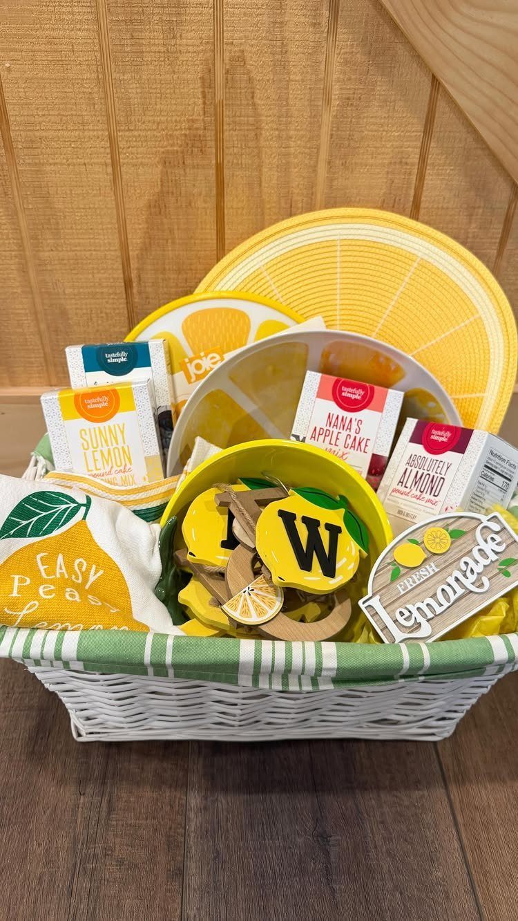 Lemon-themed gift basket with yellow plates, cakes, and a lemonade sign in wicker.