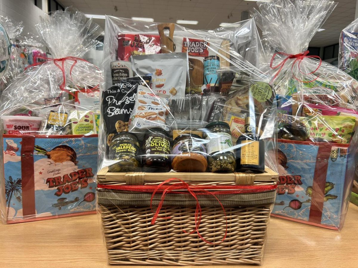 Wicker gift baskets wrapped in cellophane filled with various packaged snacks and jars.