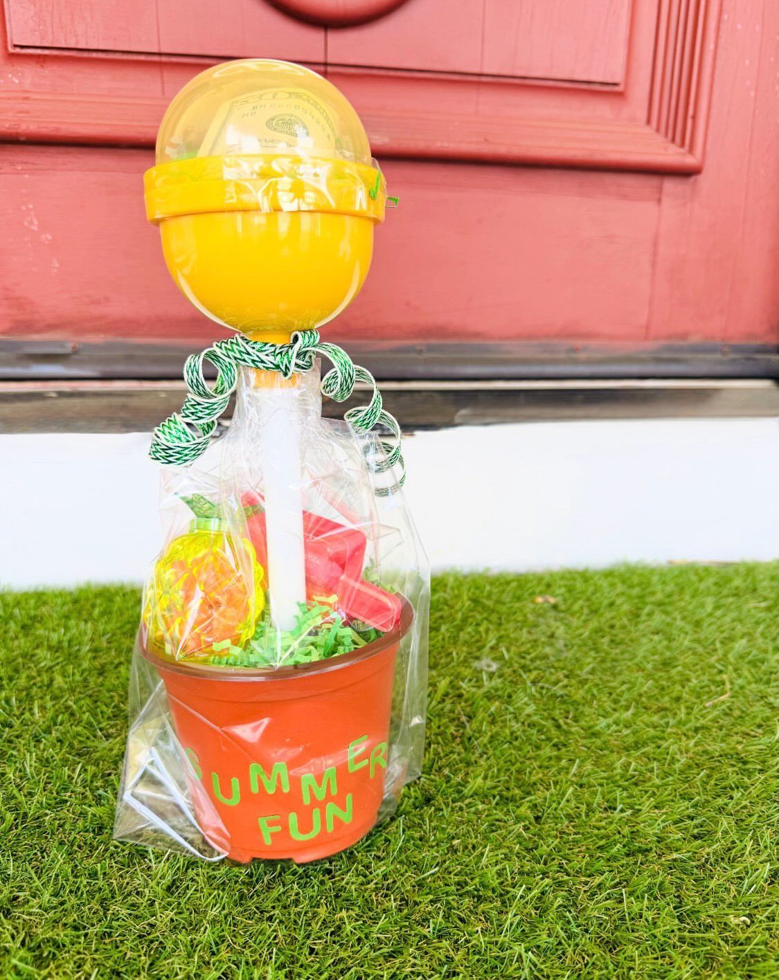 Summer fun gift basket in an orange pot with a yellow gumball machine.