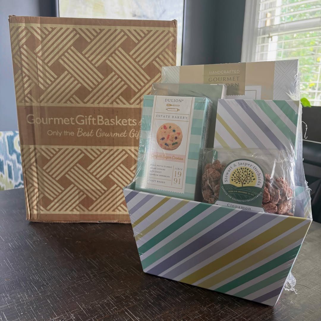 Striped gift basket filled with gourmet cookies and nuts next to shipping box