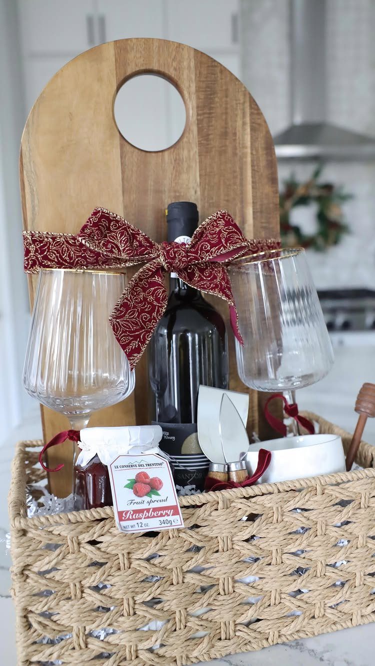 Wine gift basket with a bottle of red wine, glasses, and wooden board.