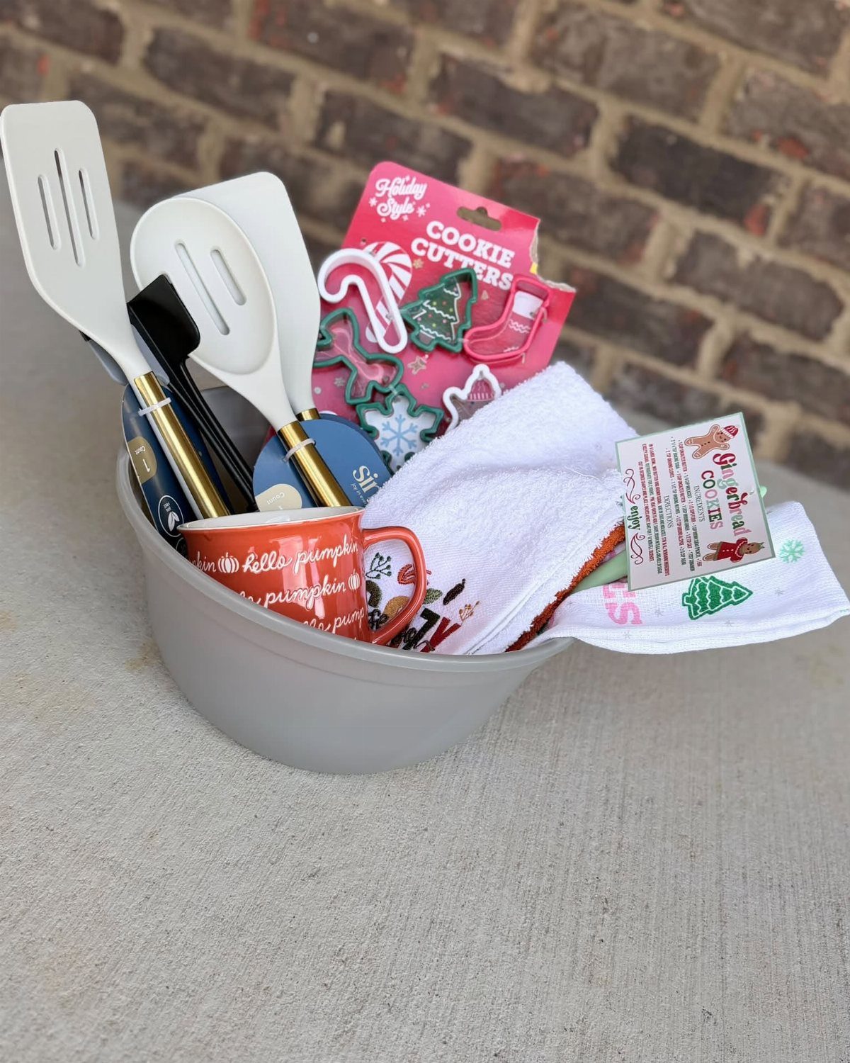 Baking gift set in a grey bowl with spatulas and cookie cutters.