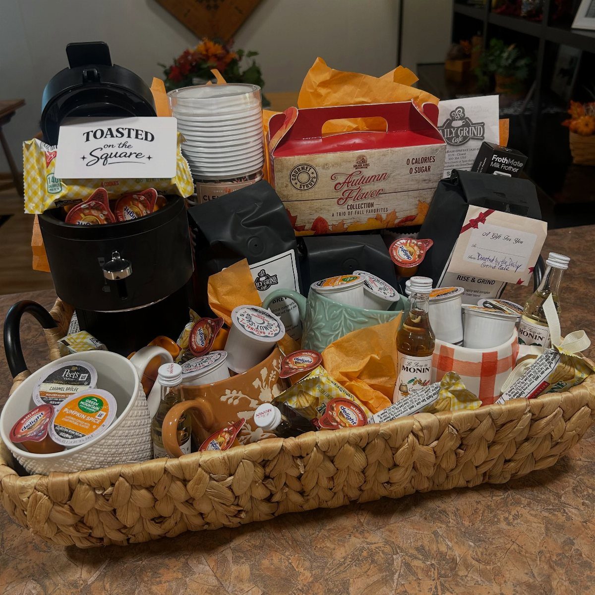 Coffee lover's raffle basket with a coffee maker, mugs, and gourmet coffee pods.