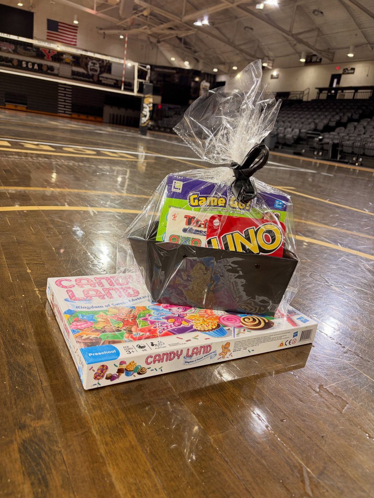 Game night raffle basket with Uno and Candy Land on a gym floor