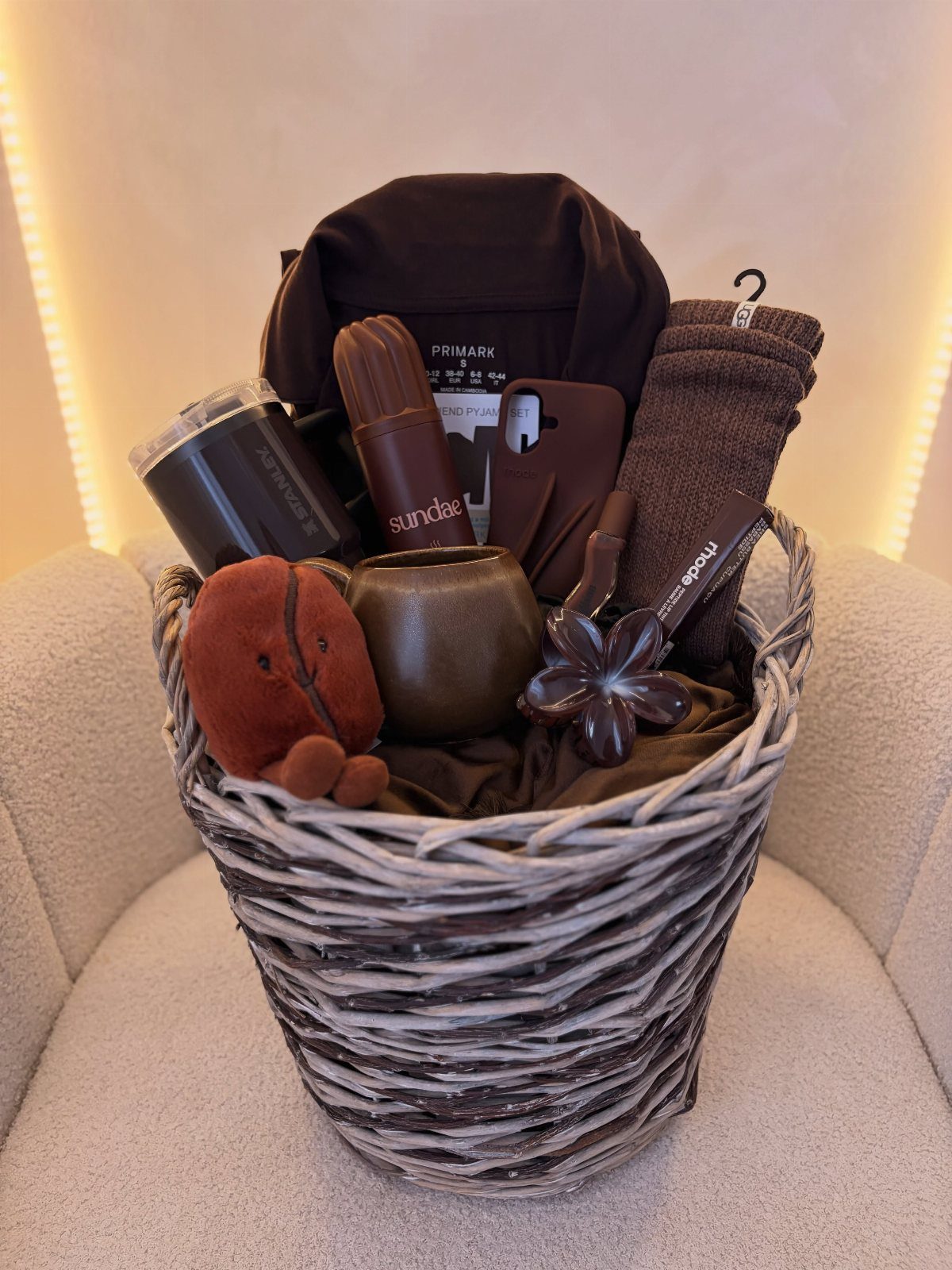 Brown themed gift basket containing a shirt, mug, and plush toy in a woven basket.