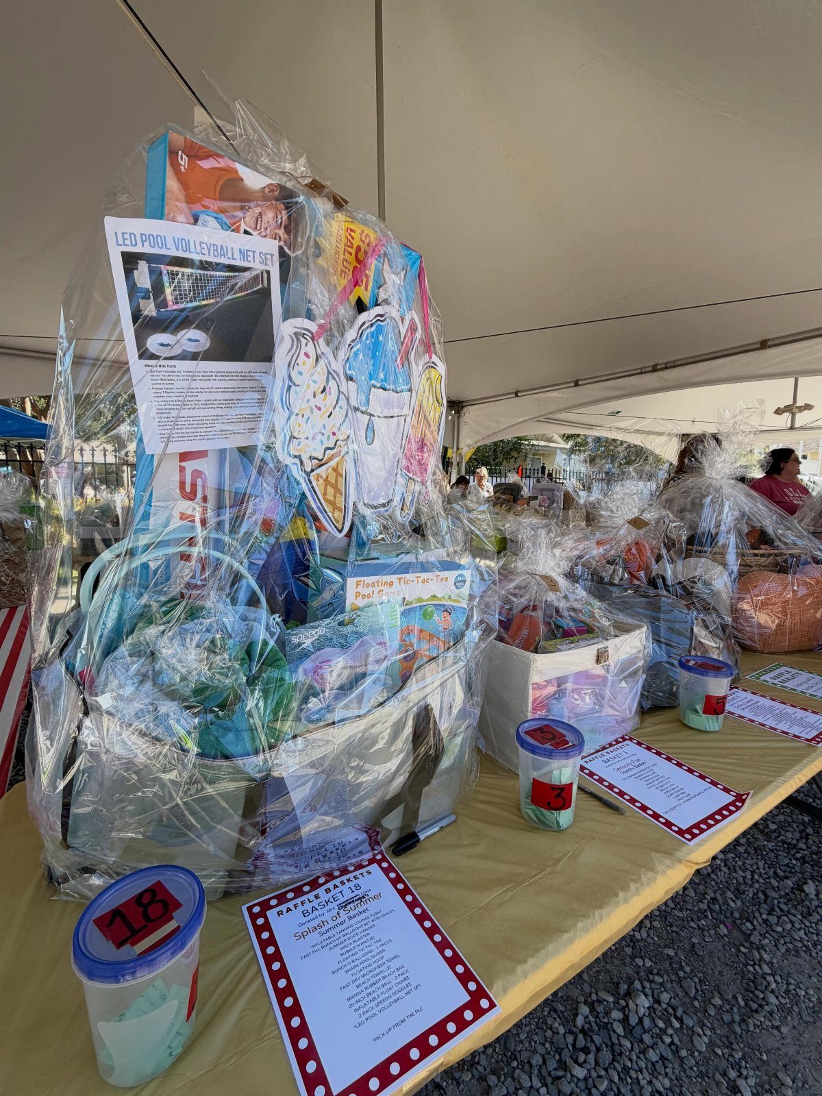Outdoor fun gift basket wrapped in cellophane with pool toys on a table.