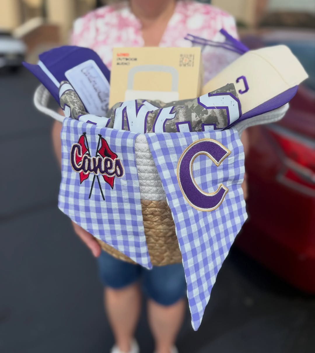 Wicker basket filled with purple and white school spirit merchandise and tickets.
