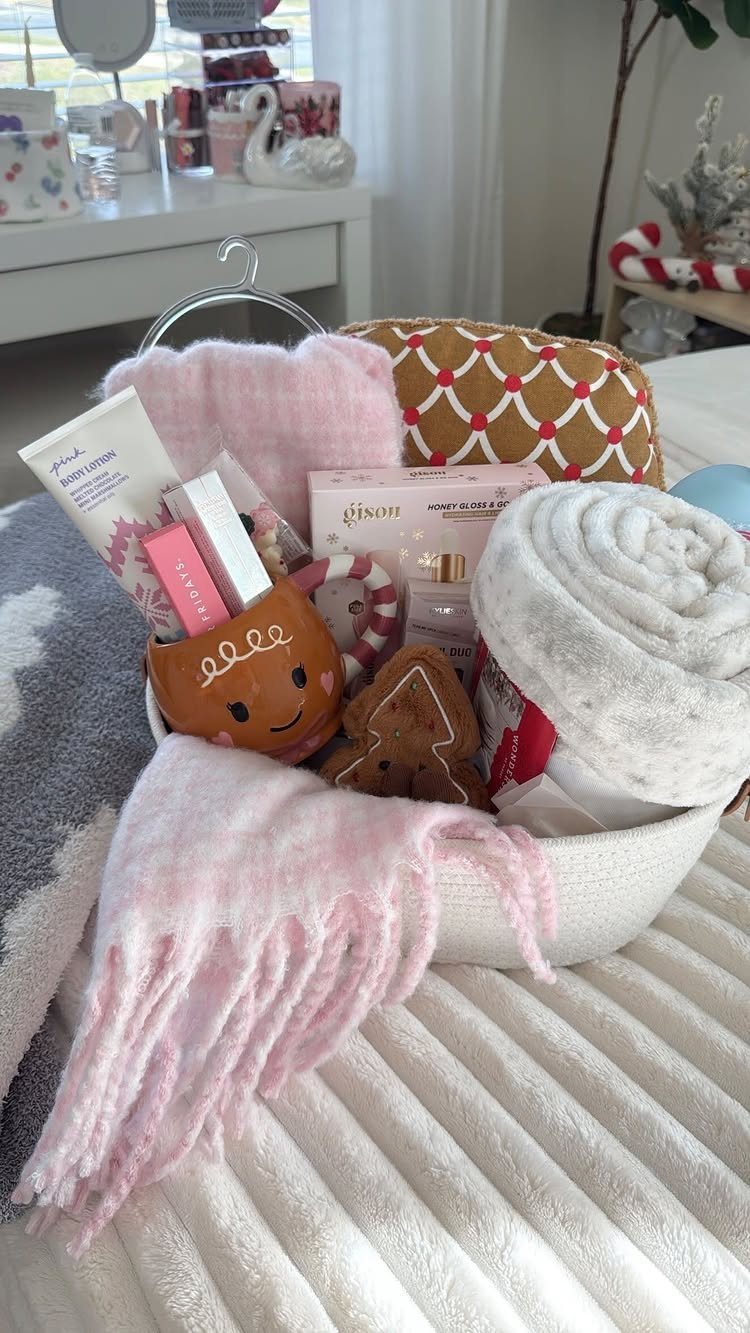 White woven basket filled with pink blankets, towels, and skincare for winter warmth.