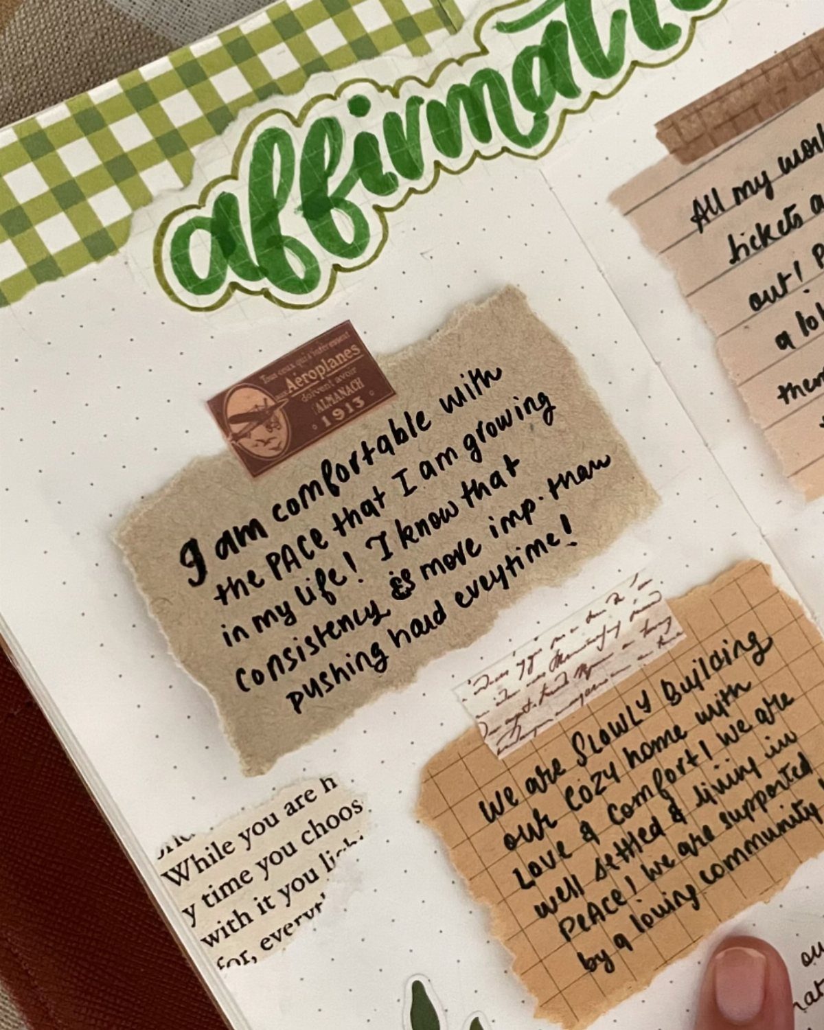 Open notebook with handwritten affirmations on torn paper and green decorative lettering.